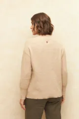 Polera de cuello redondo tejida en color marrón, con detalle de textura en el canesú y puños elastizados.