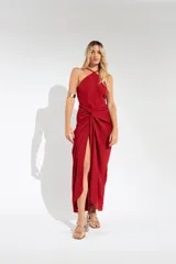 Vestido largo color naranja, con escote halter cruzado y falda tipo pareo con tajo lateral. Confeccionado en tela crepé con caída fluida.