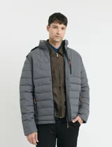 Campera puffer gris oscuro con capucha desmontable, cierre frontal con cremallera y botones a presión, bolsillos laterales con cierre y detalles en color naranja.