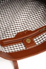 Bolso tipo shopper color marrón de cuero sintético con diseño trenzado. Cuenta con doble asa de hombro y placa metálica con el logo de la marca en el frente.