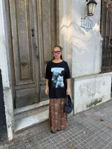 Conjunto compuesto por un remerón negro de algodón con estampa fotográfica frontal y una pollera midi de satén con estampado animal print de leopardo.