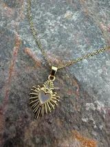 Collar dorado con cadena de eslabones y dije colgante de sagrado corazón con centro de nácar.
