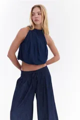 Blusa balloon de denim ultraliviano color gris oscuro, con escote halter fruncido, diseño sin mangas y dobladillo ajustado.