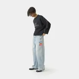 Buzo oversize de algodón color negro con cuello redondo. Presenta el logo de la marca bordado en el frente, líneas blancas en contraste a lo largo de las mangas y terminaciones con bordes deshilachados.