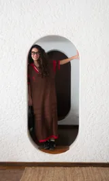 Remerón tejido de punto color azul marino con calados, cuello estilo camisa en verde oscuro con rayas blancas y verdes, y logo bordado en blanco en el pecho.