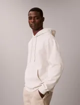 Buzo con capucha de Calvin Klein en color beige, confeccionado en mezcla de algodón y poliéster. Cuenta con bolsillo tipo canguro frontal, cordones ajustables y el monograma de la marca bordado en el pecho.