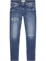 Jeans de algodón elástico, lavado a la piedra azul oscuro, con talle medio y pierna estrecha en el tobillo. Presenta roturas en ambas piernas.