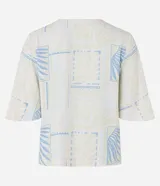 Blusa de manga corta en viscosa color beige, con escote en V con detalle de tira y cuenta de madera, y estampado geométrica y de follaje en tonos celestes.