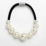 Collar corto de diseño moderno compuesto por una banda de caucho negro y perlas de plástico de distintos tamaños, con cierre magnético metálico.