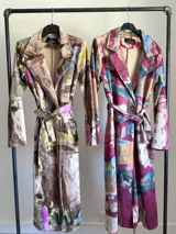 Tapado largo de mujer con estampado artístico abstracto en tonos rojizos, burdeos, azules y beige. Posee cuello solapa y calce recto.