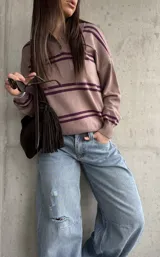 Sweater de punto color lavanda con diseño rayado en tonos morados, cuello polo con botones y mangas largas.