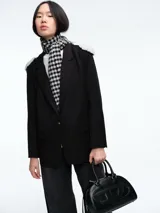 Blazer negro de corte estructurado con hombreras decoradas con apliques de perlas. Presenta cierre frontal con un botón, solapas clásicas y bolsillos laterales con solapa.