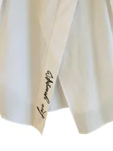 Camisa blanca de popelina con manga larga, cierre con botones delanteros y bordado en contraste en la espalda con la frase 'Love yourself'.