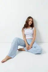 Pantalón de pijama celeste con rayas verticales finas color marrón, con bolsillos laterales y elástico en la cintura.
