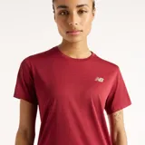Remera deportiva New Balance Athletics de manga corta y cuello redondo, color bordó, con logo reflectante de la marca en el pecho.