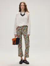 Pantalón de jean de corte recto y tiro medio con estampado floreado multicolor sobre base azul, confeccionado en algodón elastizado.