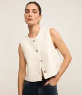 Chaleco blanco de tweed con cuello redondo, abotonado en el frente y corte entallado.