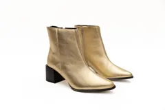 Botas cortas plateadas de cuero con punta fina y cierre lateral. Taco geométrico color negro.