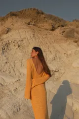 Vestido largo de tejido de punto negro con escote en la espalda y mangas largas.