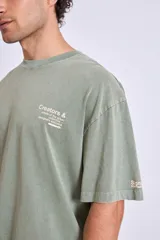 Remera de algodón color marrón con efecto lavado, corte oversize y estampa pequeña en el pecho.