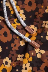 Short de baño con estampado floral en tonos marrones y amarillos, con cintura elástica ajustable con cordón.