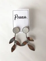 Par de aros colgantes plateados con forma de hojas y círculos de nácar.