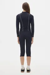 Calza capri negra de tiro alto con protección UV factor 50 y detalle de línea blanca en los laterales.