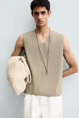 Chaleco de punto color beige claro, con cuello en V y corte relajado sin mangas.