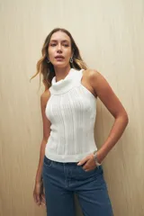 Musculosa blanca de tejido de punto calado, con cuello alto tipo polera y corte ajustado.