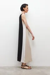 Vestido midi de lino color beige con laterales blancos, escote en V y cinturón negro con hebilla redonda.