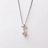 Conjunto de collar y aros en plata 925 con perlas de río y circonias. El collar tiene una cadena de 42cm y dos perlas colgantes de 6,5mm y 8,5mm.