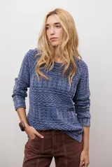 Buzo de tejido de punto en color azul con diseño geométrico texturizado, cuello redondo y mangas largas.