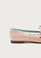 Bailarina de piel natural color rosa pálido, con detalle de lazo de tul transparente con lunares negros y ojales metálicos plateados en los laterales.