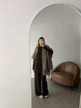 Ruana negra de tejido liviano con terminación de flecos en el ruedo y mangas amplias.