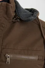 Campera técnica de tejido elástico en color azul marino, con capucha ajustable, cierre frontal y bolsillos laterales con cierre. Cuenta con forro interior de micro polar y ajuste en el ruedo.