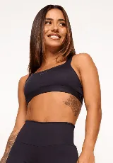 Top deportivo negro con breteles gruesos y ajustables, abertura interna para almohadillas removibles y detalles reflectantes.