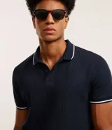 Polo de hombre marca Marfinno, confeccionada en tejido de media malla con textura rayada. Presenta cuello polo con botones y mangas cortas con terminaciones en rib con detalles contrastantes.