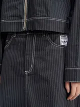 Falda larga Adidas color negro con finas rayas verticales blancas, corte recto, tiro alto y logo bordado en el bolsillo trasero.