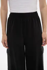 Pantalon de corte amplio y tiro alto, confeccionado en poliester, con bolsillos laterales tipo cargo.