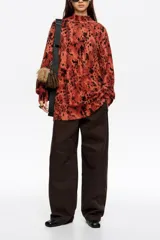 Jersey de pelo con cuello alto, manga larga y diseño holgado. Presenta un estampado animal print difuminado en tonos rojizos y negros.