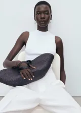 Top de punto canalé color blanco, de diseño entallado con cuello redondo y tirantes anchos sin mangas.