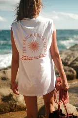 Camiseta blanca oversize de algodón, con cuello a la base y manga corta. Presenta una gran estampa en la espalda y un detalle estampado en la parte delantera.