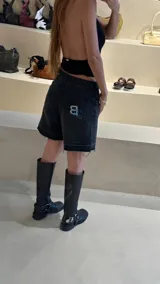 Bermuda de jean negro con ruedo desflecado y bordado con logo en el bolsillo trasero.