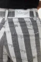 Pantalón de jean de corte recto y tiro alto con estampado de rayas verticales en tonos rosados. Cuenta con cierre frontal y bolsillos laterales.