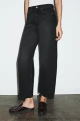 Jeans de tiro medio con corte relajado y largo al tobillo. Presenta diseño de cinco bolsillos, trabillas en la cintura y cierre frontal con cremallera y botón metálico.