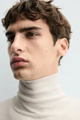 Jersey negro de punto fino con cuello alto y manga larga.