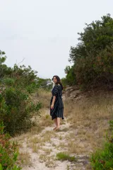 Vestido túnica midi de corte recto, color azul marino con rayas verticales blancas, mangas cortas abullonadas y lazo ajustable en la cintura.