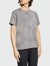 Remera de algodón con efecto lavado y textura desgastada, cuello redondo y manga corta. Presenta un pequeño logo bordado en el pecho.