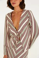 Camisa larga de viscosa con estampado de rayas verticales en tonos crudo, verde y borgoña. Tiene escote en V profundo con cordones para anudar y mangas largas fluidas.