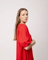 Vestido corto rojo de lino con escote bote y mangas abullonadas.